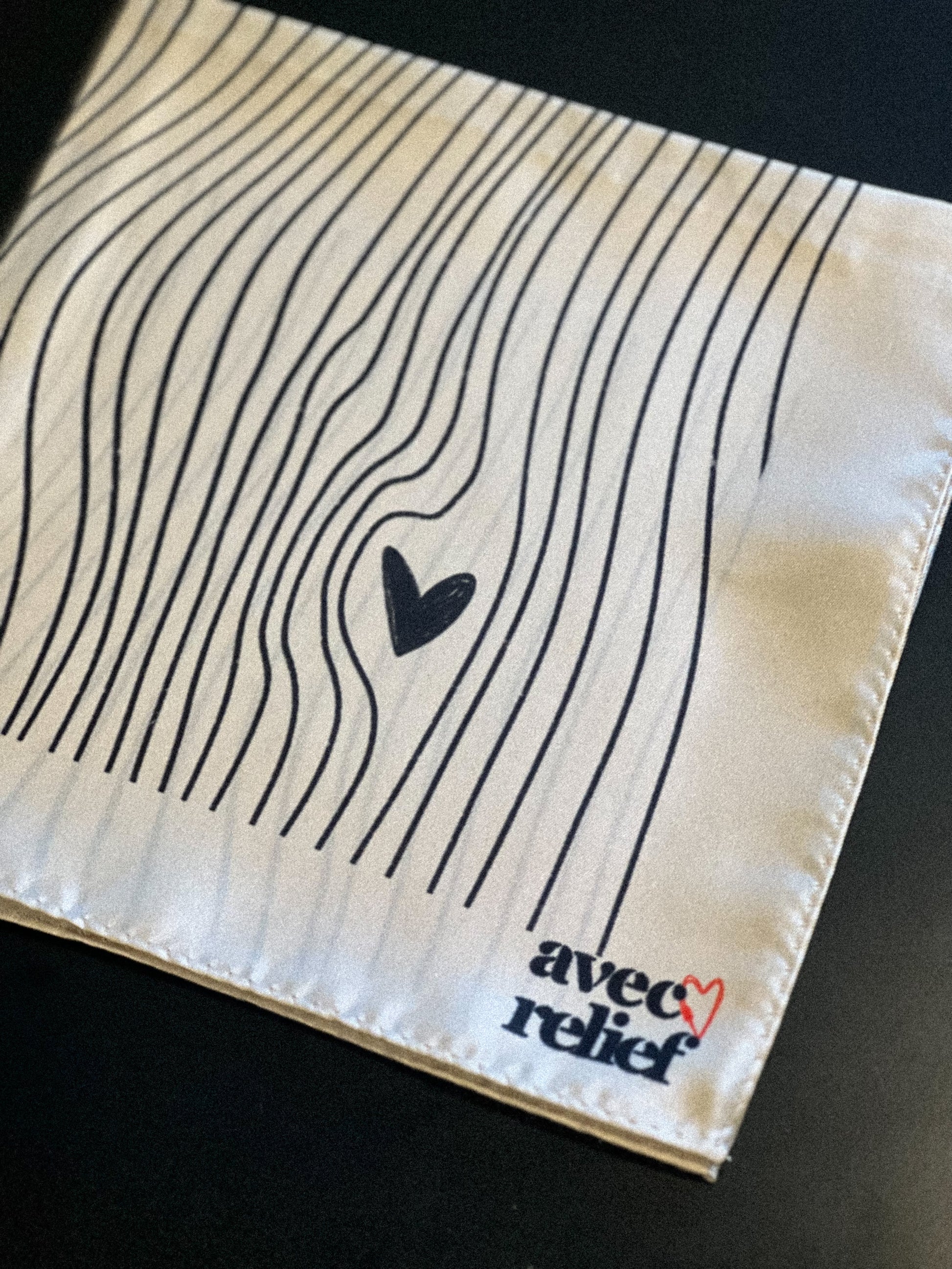 foulard 100% soie, design beige avec des motif lignes courbées et coeurs noires. Avec logo Avec Relief 